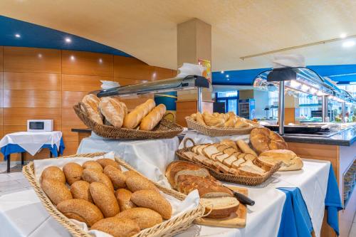 a group of baskets of bread on tables in a bakery at Hotel Rober Palas in Albir