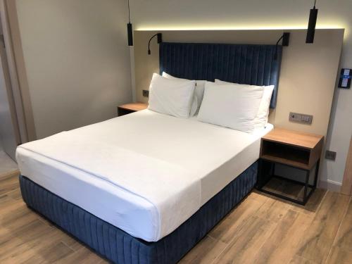 a bedroom with a large bed with white sheets and pillows at The Palm Bosphorus Hotel in Istanbul