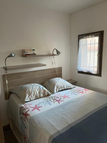 - une chambre avec un lit et une étagère sur le mur dans l'établissement Calme et confort en rez-de-jardin, à La Londe-les-Maures