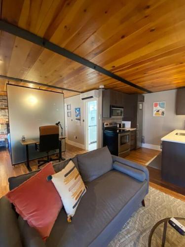 a living room with a couch and a kitchen at The Lofts #3 - Cozy downtown studio getaway in Kingston