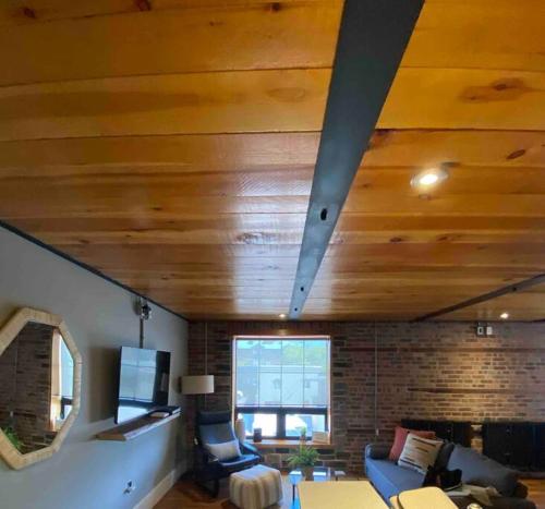 a living room with a wooden ceiling and a couch at The Lofts #3 - Cozy downtown studio getaway in Kingston