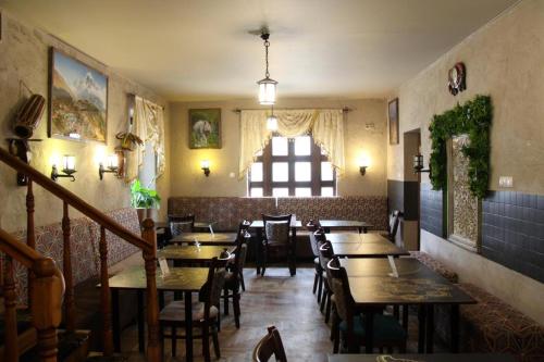 a restaurant with wooden tables and chairs and a window at Nobilton Hotel in Kraków