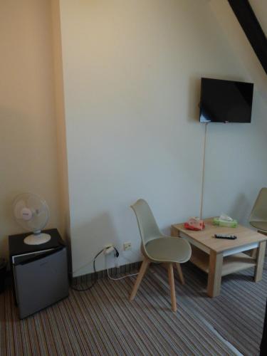 a room with a table and a chair and a tv at Hotel Svornost in Prague