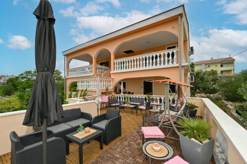 balcone con mobili da giardino e ombrellone di Villa Schubert a Novalja (Novaglia)