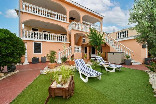 una casa con cortile, sedie e patio di Villa Schubert a Novalja (Novaglia)