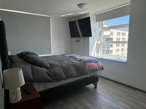 a bedroom with a bed and a large window at Depto Centro Viña in Viña del Mar