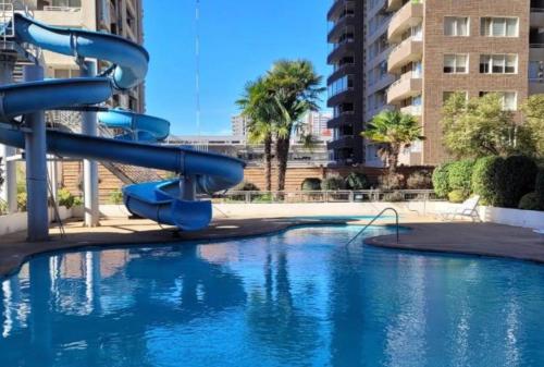 a blue water slide in a swimming pool at Depto Centro Viña in Viña del Mar