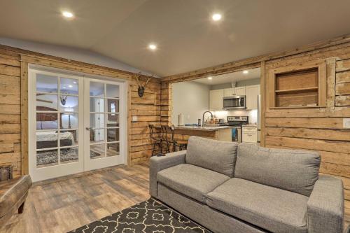 a living room with a couch and a kitchen at Rustic Anchorage Hideaway Walk to Coastal Trail! in Anchorage