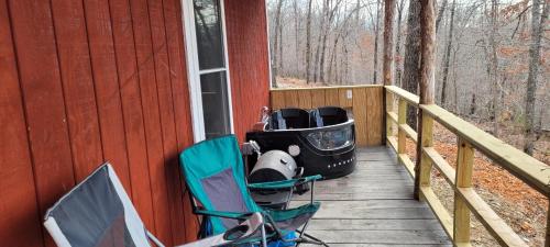 a deck with two chairs and a grill on a house at The Windstorm Cabin - Pet-friendly & a 2-person Jacuzzi hot tub! in Marshall