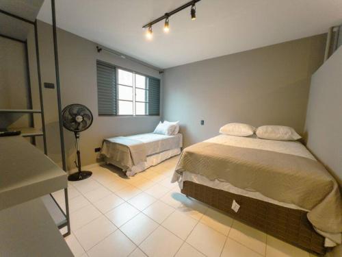 a bedroom with a bed and a fan at Apartamento Moderno Zona 7 LP13 in Maringá