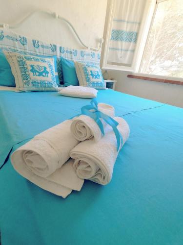 a blue bed with towels on top of it at Villa Anna 300 m dal mare in Torre delle Stelle