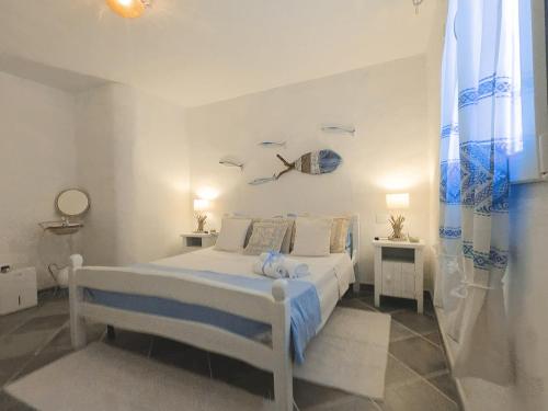 a white bedroom with a bed with birds on the wall at Villa Anna 300 m dal mare in Torre delle Stelle