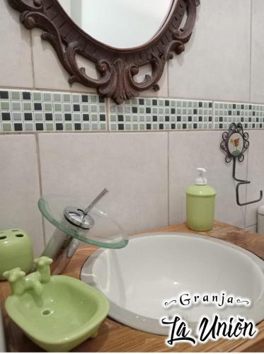 a bathroom with a sink and a mirror and a tub at Granja La Unión in Villa Dolores