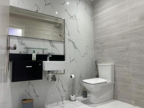 Un baño con un inodoro blanco y un lavabo. en résidence Hivernage, en Marrakech