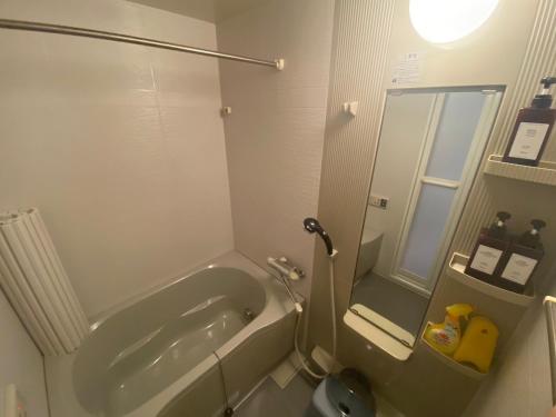 a bathroom with a shower and a tub and a toilet at 貸切御宿 和 Nagomi in Utsunomiya