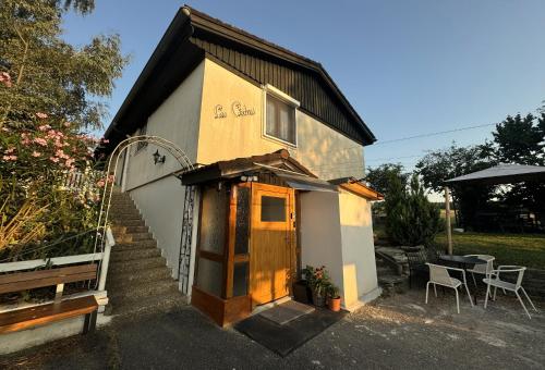 a small house with a door and a table and chairs at Joli Appartement paisible in Corcelles-sur-Chavornay