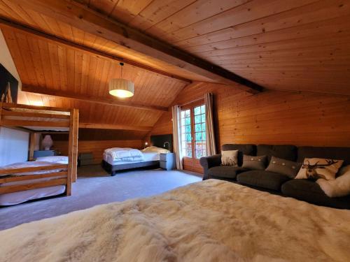 une chambre avec un lit et un canapé dans une pièce dans l'établissement Chalet de prestige 5* aux Gets avec jacuzzi et cheminée - FR-1-598-39, aux Gets