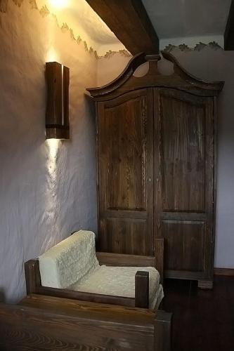 a wooden bed in a room with a wooden cabinet at Kompleks rekreacyjno- hotelowo-wypoczynkowy FIRLEJOWE SIOŁO in Karolina