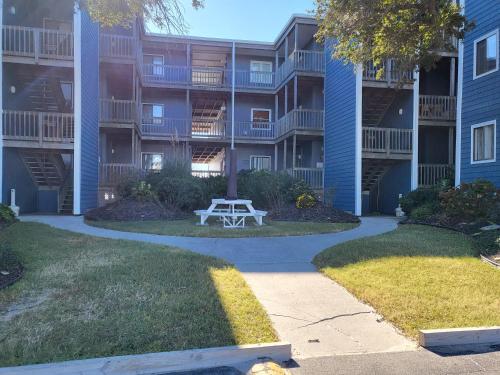 a picnic table in front of a apartment building at Beachfront Bungalow 125 in North Topsail Beach