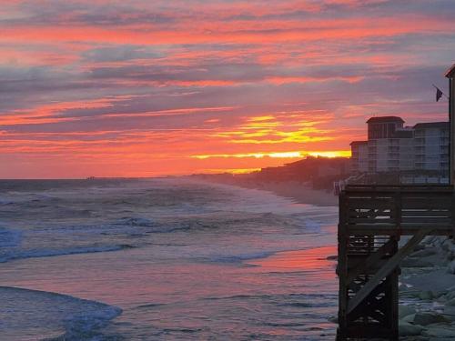 a sunset on the beach with the ocean at Beachfront Bungalow 125 in North Topsail Beach
