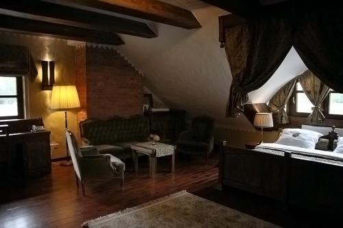 a bedroom with a bed and a couch and a table at Kompleks rekreacyjno- hotelowo-wypoczynkowy FIRLEJOWE SIOŁO in Karolina