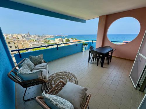 einen Balkon mit Stühlen, einem Tisch und Meerblick in der Unterkunft Dimora Girasole in Monopoli