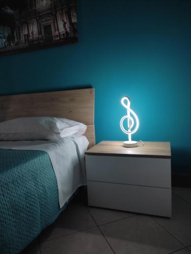 a lamp on a night stand next to a bed at Kamurria House in Catania