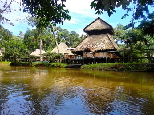 a group of huts next to a river at Cuyabeno River Lodge in Marian