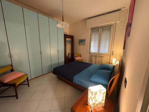 a bedroom with a blue bed and a chair at 5 Terre Express Holiday House - Migliarina in Isola