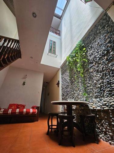 a room with a table and a stone wall at HOME Penang in George Town