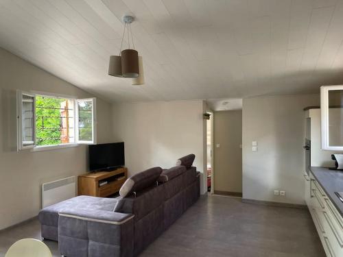 un salon avec un canapé et une télévision dans l'établissement Villa 250 m plage 6 personnes La Villanat, à Sérignan