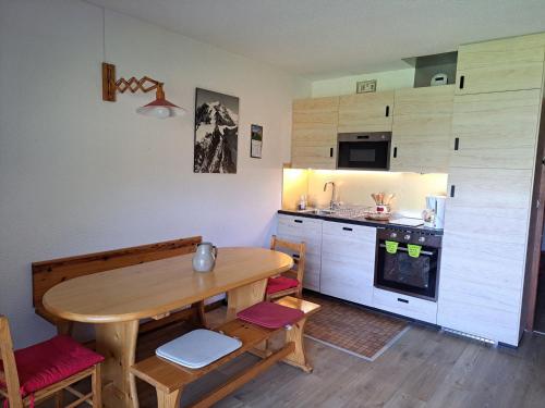 une cuisine avec une table en bois et une salle à manger dans l'établissement Appartement standard avec balcon, parking et ascenseur à Albiez-Montrond - FR-1-618-9, à Albiez-Montrond
