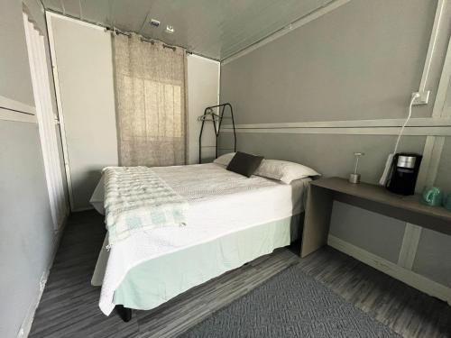 a small bedroom with a bed and a window at La 10a de Las Charcas in Guatemala