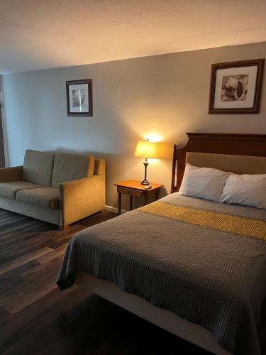 a hotel room with a bed and a couch at APM Inn & Suites in Martinsburg