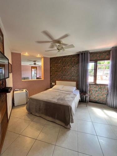 a bedroom with a bed and a ceiling fan at Pousada Vila do Imperador in Diamantina