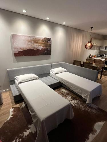 a living room with two beds and a couch at Aconchego Serra Class 205 Piscina, espaço kids, academia, sauna in Canela