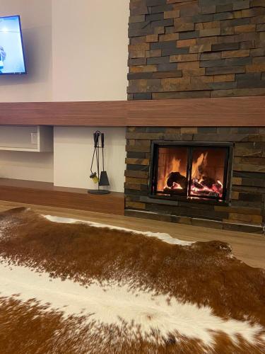 a fireplace in a living room with a fire place at Aconchego Serra Class 205 Piscina, espaço kids, academia, sauna in Canela