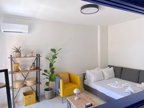 a living room with a bed and a yellow chair at Blue Cozy Nest in Rhodes Town