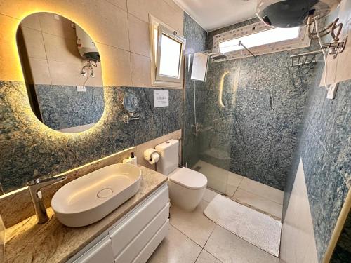 a bathroom with a sink and a toilet and a mirror at Beit Reihana in Dahab