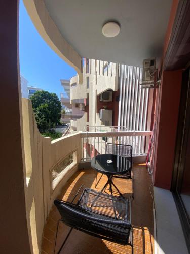 a balcony with two chairs and a table on it at Blue Cozy Nest in Rhodes Town