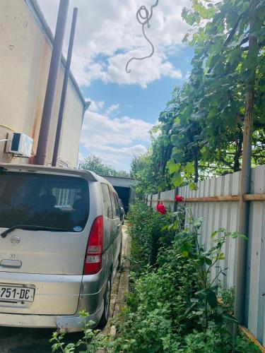 a car parked in a driveway next to a fence at Uplistsikhe guest "Paluma" in Kʼvakhvreli