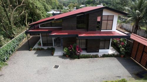a house with a red roof and a driveway at Hector House in Uvita