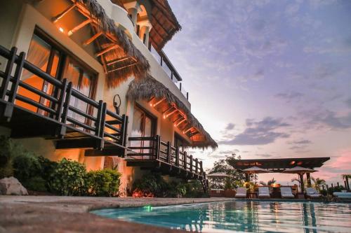 a hotel with a swimming pool in front of a building at Casa Colina in Isla Navidad