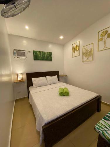 a bedroom with a bed with two green towels on it at Kalipay Bungalows Alcoy in Alcoy
