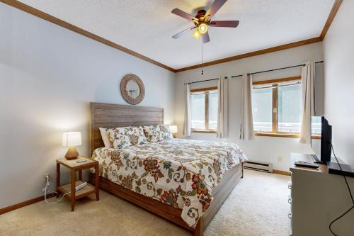 Un dormitorio con una cama y un ventilador de techo. en Skyleaf 703, en Sugar Mountain