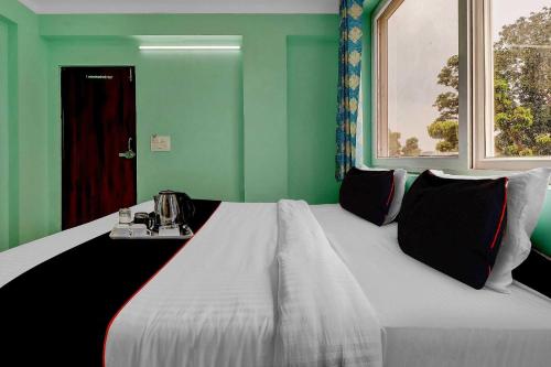 a large bed in a room with green walls at Super Collection O The Kailash Hotel in Dehradun