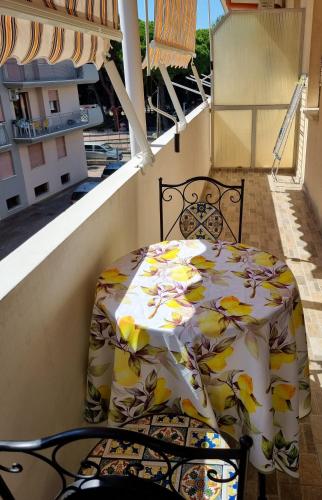 a bed on a balcony with a table and chairs at Relax Rosolina Mare in Rosolina Mare