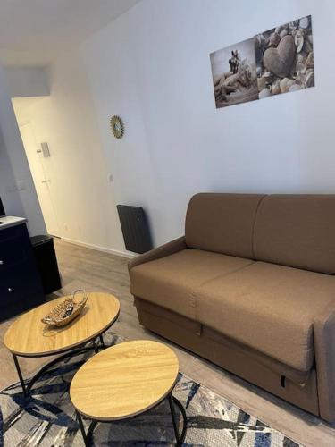 a living room with a couch and two tables at Studio cosy hyper centre in Évian-les-Bains