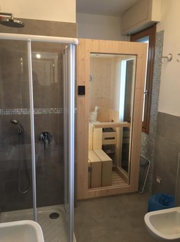a bathroom with a shower and a sink and a mirror at Miralago stunning view over Varenna in Perledo