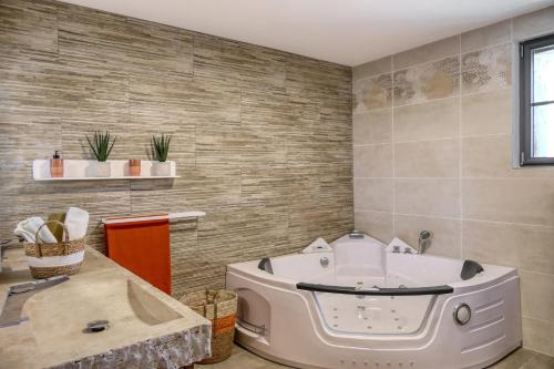 Cette chambre comprend une salle de bains pourvue d'une grande baignoire. dans l'établissement Sous le mûrier - Mas Provençal au coeur des vignes, à Travaillan